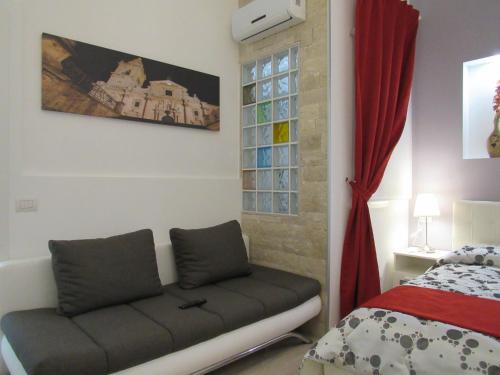 a living room with a couch next to a bed at La Voce del Violino in Ragusa