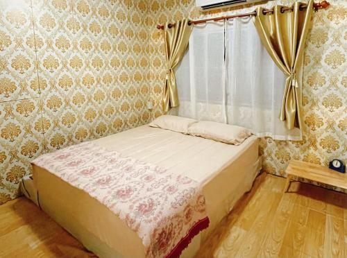 a bedroom with a bed and a window with curtains at บ้านคุณยายอยุธยา in Phra Nakhon Si Ayutthaya