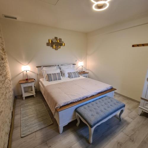 - une chambre avec un grand lit et un tabouret bleu dans l'établissement Mazet indépendant pour 2 personnes à St Rémy, à Saint-Rémy-de-Provence