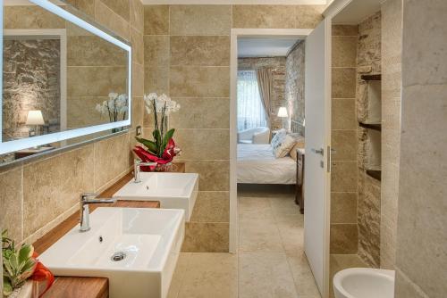 ein Badezimmer mit 2 Waschbecken und einem Spiegel in der Unterkunft Borgo Canapegna - 2 private villas and 3 private pools in the heart of Le Marche in Fabriano