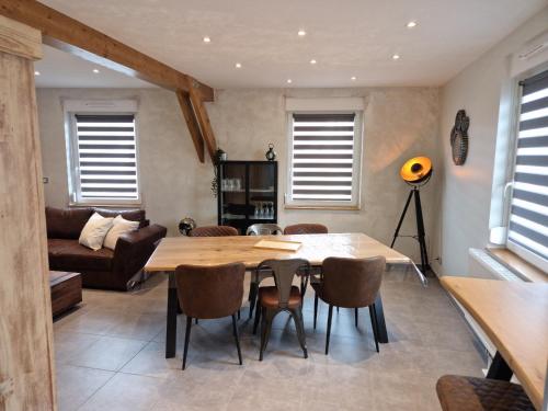 - un salon avec une table et des chaises en bois dans l'établissement Appartement, proche Europa-Park Colmar Strasbourg, à Sundhouse