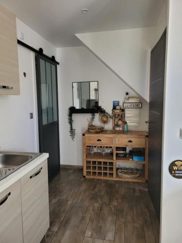 Il comprend une cuisine avec un évier et du parquet. dans l'établissement Cosy wood Loc T2 