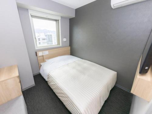 Ein Bett oder Betten in einem Zimmer der Unterkunft Super Hotel Sapporo Kitagojo Dori