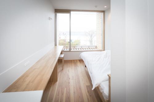 a bedroom with a bed and a large window at Teshima ESPOIR PARK in Ieura