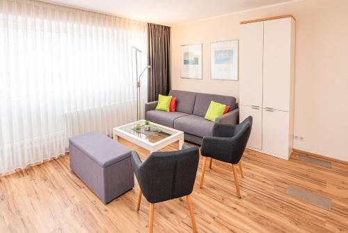 a living room with a couch and chairs and a table at Haus Inselkieker Wohnung 4 in Norderney