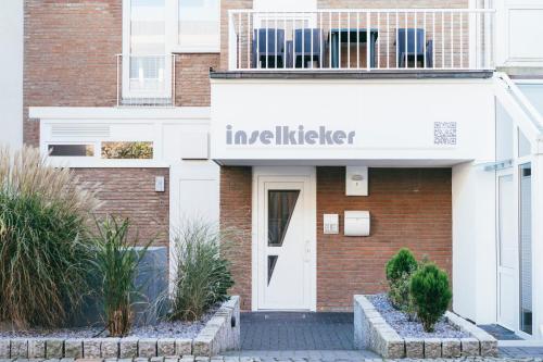 a building with a sign that reads investigate at Haus Inselkieker Wohnung 4 in Norderney