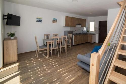 a living room and kitchen with a table and chairs at Comfortable two story holiday houses Jaros awiec in Jarosławiec