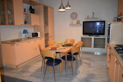 cocina con mesa y sillas y TV en MONOPOLI MIA en Monopoli