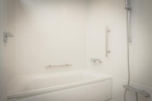 a white bathroom with a tub and a shower at Teshima ESPOIR PARK in Ieura