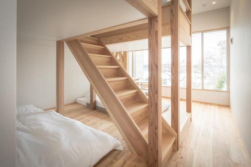 ein Schlafzimmer mit einer Holztreppe, die zu einem Bett führt in der Unterkunft Teshima ESPOIR PARK in Ieura