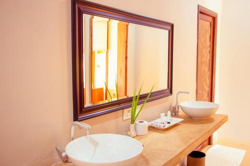 La salle de bains est pourvue d'un lavabo et d'un miroir. dans l'établissement Mandarin Resort Zanzibar, à Kizimkazi
