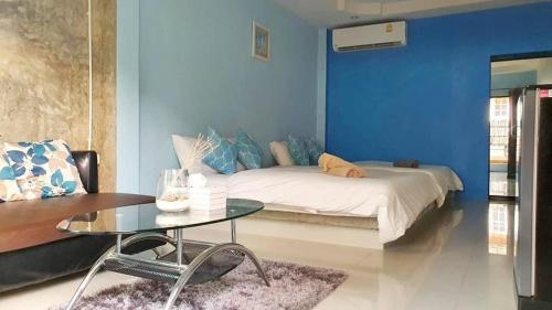 a blue room with a bed and a glass table at Mawin Resort Kohlarn in Ko Larn