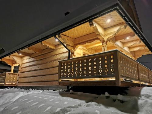 a wooden cabin with snow on the ground at Chaty Misiagi in Poronin