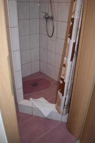 a bathroom with a shower with a white shower curtain at Ośrodek Wypoczynkowy Ania Dźwirzyno in Dźwirzyno