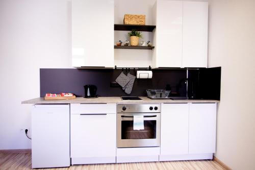 a kitchen with white cabinets and a stove at Apartmán RADKA in Zvolen