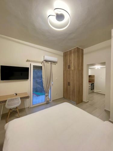 a bedroom with a bed and a desk and a window at Lemnos Urban Escape in Mirina