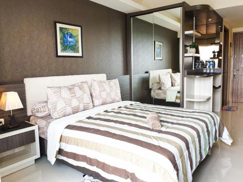 a bedroom with a large bed and a mirror at Galeri Ciumbuleuit 3 by AYA Stays in Bandung