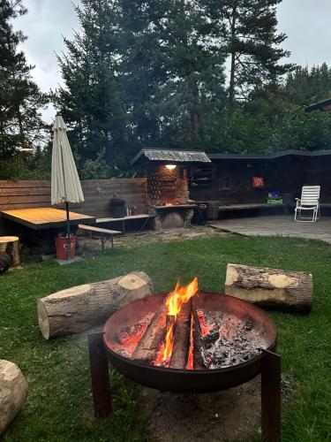 a fire pit in a yard with a grill at Ferienhaus im Wald in Edelschrott