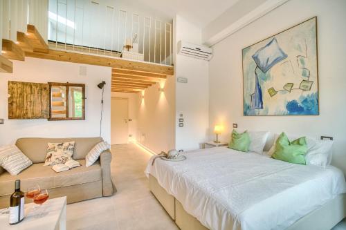 ein Schlafzimmer mit einem großen Bett und einem Sofa in der Unterkunft Borgo Canapegna - 2 private villas and 3 private pools in the heart of Le Marche in Fabriano