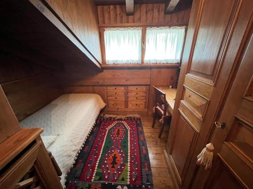 Kleines Zimmer mit einem Bett und einem Schreibtisch. in der Unterkunft Mansarda di pregio in San Vito di Cadore