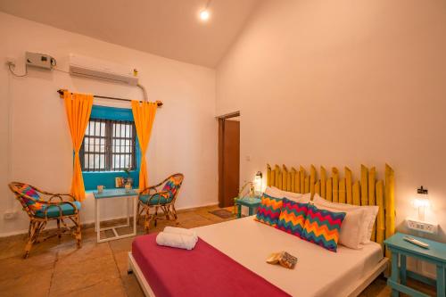 a bedroom with a bed and a table and chairs at goSTOPS Goa, Calangute in Calangute