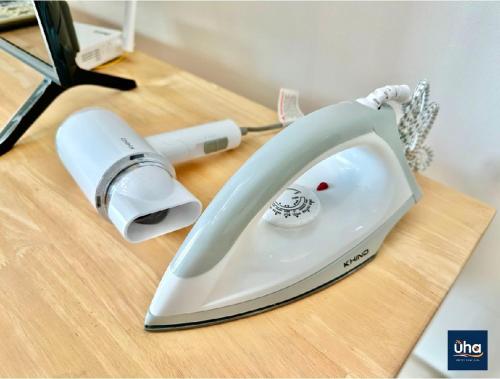 a white iron sitting on top of a wooden table at Macrolink Medini by RR JBcity in Nusajaya