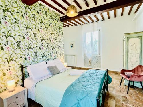 1 dormitorio con 1 cama y una pared con flores en Agriturismo CasaViVa, en Pozzo