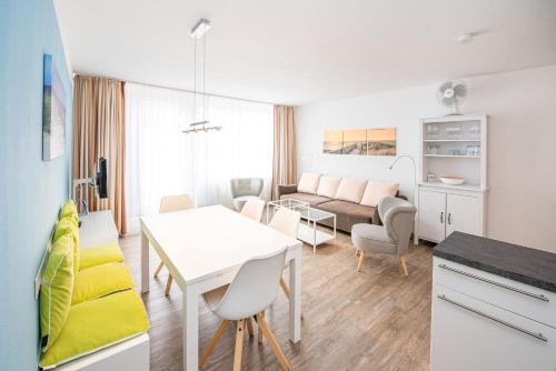 a living room with a table and a couch at Haus Inselkieker Wohnung 02 in Norderney