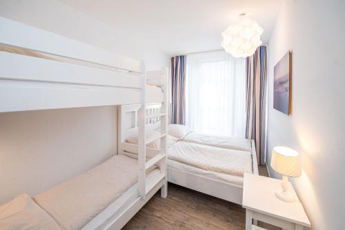1 dormitorio con 2 literas y escritorio en Haus Inselkieker Wohnung 02, en Norderney