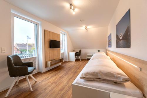 een slaapkamer met een groot bed en een stoel bij Haus Inselkap Wohnung 2 in Norderney