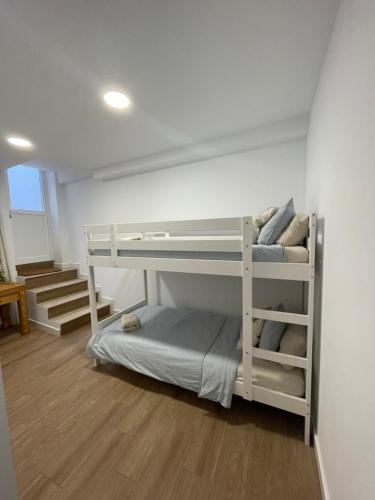 2 Etagenbetten in einem Zimmer mit einer Treppe in der Unterkunft Casa Luna de Antequera in Antequera