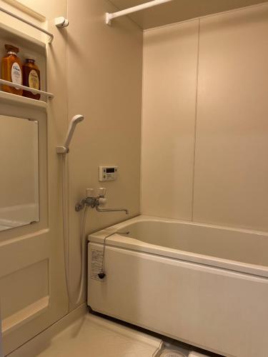 a bathroom with a bath tub next to a door at 小団体大関係 in Toda