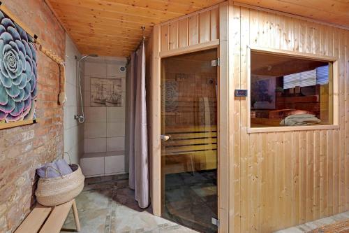 baño de madera con ducha y puerta de cristal en Sauna Retreat w Zaułku Św Bartłomieja by Downtown Apartments en Gdansk