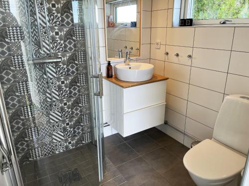 y baño con lavabo y ducha. en Cozy cottage located on a nice sea plot on Boholmarna outside Kalmar en Kalmar