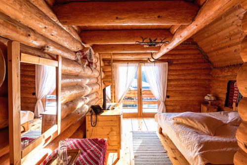 sypialnia w drewnianym domku z łóżkiem i oknem w obiekcie Turist Suior Cota 1000 w mieście Baia Sprie