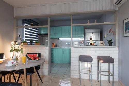 a kitchen with blue cabinets and a table and chairs at Ikaros Lodge in Agia Pelagia