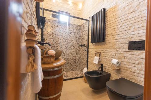 ein Bad mit einem schwarzen WC und einem Waschbecken in der Unterkunft VILLA I MORI 4, Emma Villas in Rosolini