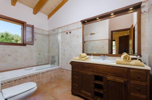 a bathroom with a sink and a toilet and a mirror at Es Vedat 4 in Lloret de Vistalegre