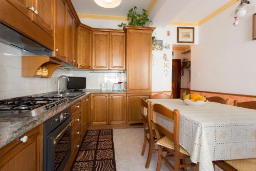 uma cozinha com armários de madeira e uma mesa com uma tigela de fruta em Casa Bellavista em Amalfi