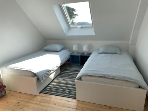 Duas camas num pequeno quarto com uma janela. em Chambres d'Hôtes B&B Roz Rozenn em Sauzon