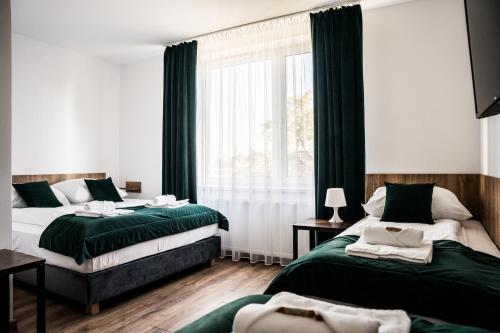 - une chambre avec 2 lits et une fenêtre dans l'établissement Apartamenty W Centrum Chrzanowa, à Chrzanów