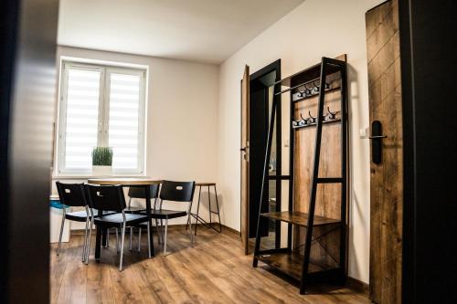 d'une salle à manger avec une table, des chaises et une fenêtre. dans l'établissement Apartamenty W Centrum Chrzanowa, à Chrzanów