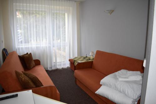 a living room with a couch and a window at Ośrodek Wypoczynkowy Ania Dźwirzyno in Dźwirzyno