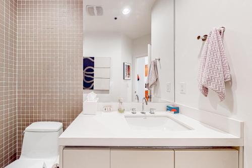 a white bathroom with a tub and a toilet at Modern Park City Condo in Park City