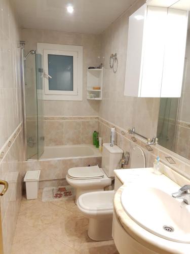 ein Bad mit einem WC, einem Waschbecken und einer Dusche in der Unterkunft Habitacion Acogedora en piso compartido cerca del Camp Nou in Hospitalet de Llobregat