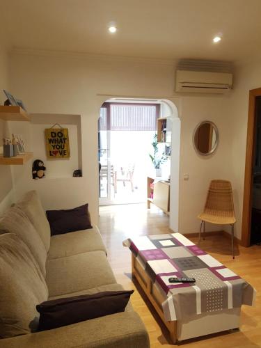 ein Wohnzimmer mit einem Sofa und einem Tisch in der Unterkunft Habitacion Acogedora en piso compartido cerca del Camp Nou in Hospitalet de Llobregat