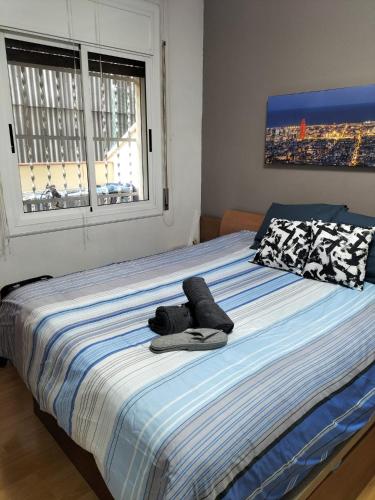 ein Bett mit einem Paar Schuhe drauf in der Unterkunft Habitacion Acogedora en piso compartido cerca del Camp Nou in Hospitalet de Llobregat