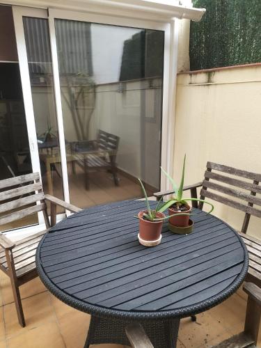 einen blauen Tisch mit zwei Topfpflanzen auf einer Terrasse in der Unterkunft Habitacion Acogedora en piso compartido cerca del Camp Nou in Hospitalet de Llobregat