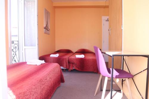 a room with two beds and a table and chairs at Hôtel restaurant Le Parisien in Lourdes