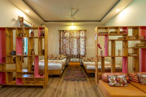 - une chambre avec des lits superposés et un canapé dans l'établissement GiriSadan Organic Farm Retreat & Botanical Forest, à Jaipur